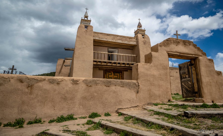 An exterior view of the San Jose de Gracia Catholic Church, built in 1760, in Las Trampas, New Mexico, Friday, April 14, 2023. Threatened by depopulation, dwindling congregations and fading traditions, some faithful are fighting to save their historic adobe churches and the uniquely New Mexican way of life they represent. (AP Photo/Roberto E. Rosales)