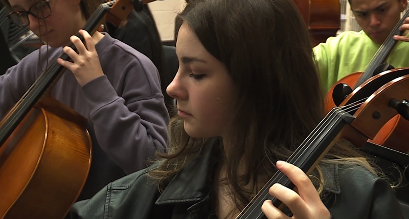 McKay High School junior Naomi Warren plays the cello during orchestra practice, April 2023 (KOIN)