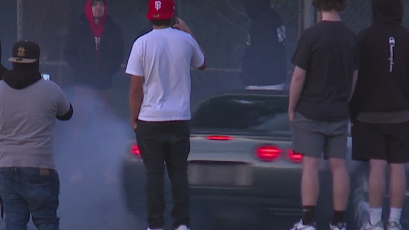 Onlookers use cell phones to take video of street racers along North Columbia near Peninsular in Portland, April 30, 2023 (KOIN)