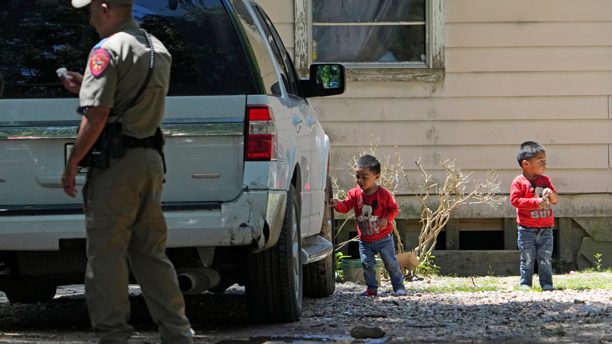 Josue, left, and Nathan Barcenas play outside their home as law enforcement continues to investigate the neighborhood Sunday, April 30, 2023, where a mass shooting occurred Friday night, in Cleveland, Texas. The search for a Texas man who allegedly shot his neighbors after they asked him to stop firing off rounds in his yard stretched into a second day Sunday, with authorities saying the man could be anywhere by now. Francisco Oropeza, 38, fled after the shooting Friday night that left five people dead, including a young boy. (AP Photo/David J. Phillip)