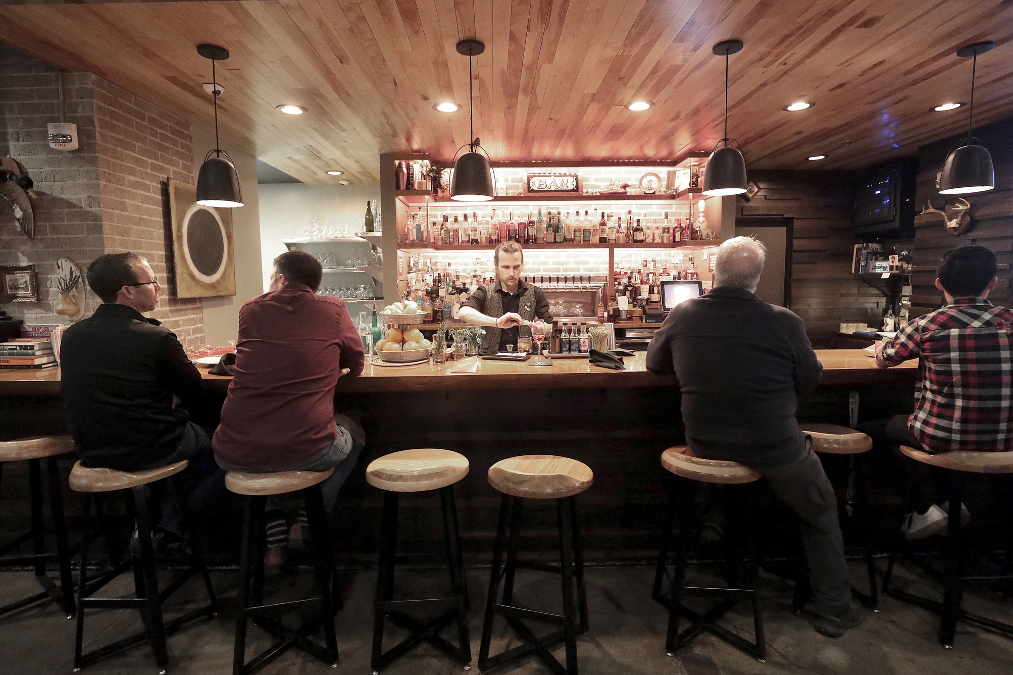 FILE - Patrons sit in a hotel bar in Eau Claire, Wis., May 1, 2019. Fourteen-year-olds in Wisconsin could serve alcohol to seated customers in bars and restaurants under a bill circulated for cosponsors Monday, May 1, 2023, by a pair of Republican state lawmakers. (John Hart/Wisconsin State Journal via AP, File)