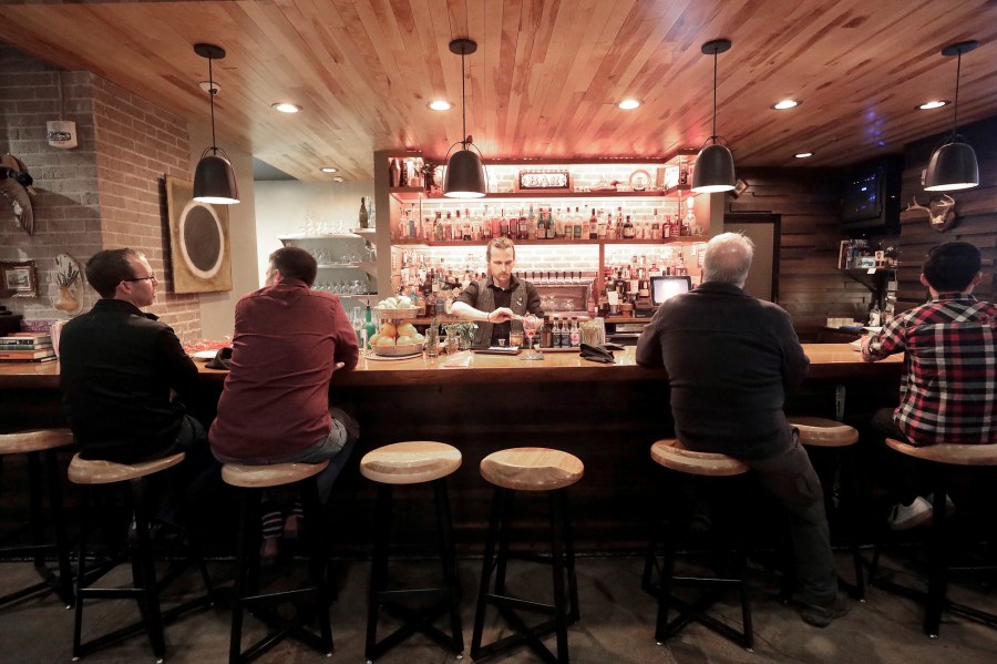 FILE - Patrons sit in a hotel bar in Eau Claire, Wis., May 1, 2019. Fourteen-year-olds in Wisconsin could serve alcohol to seated customers in bars and restaurants under a bill circulated for cosponsors Monday, May 1, 2023, by a pair of Republican state lawmakers. (John Hart/Wisconsin State Journal via AP, File)