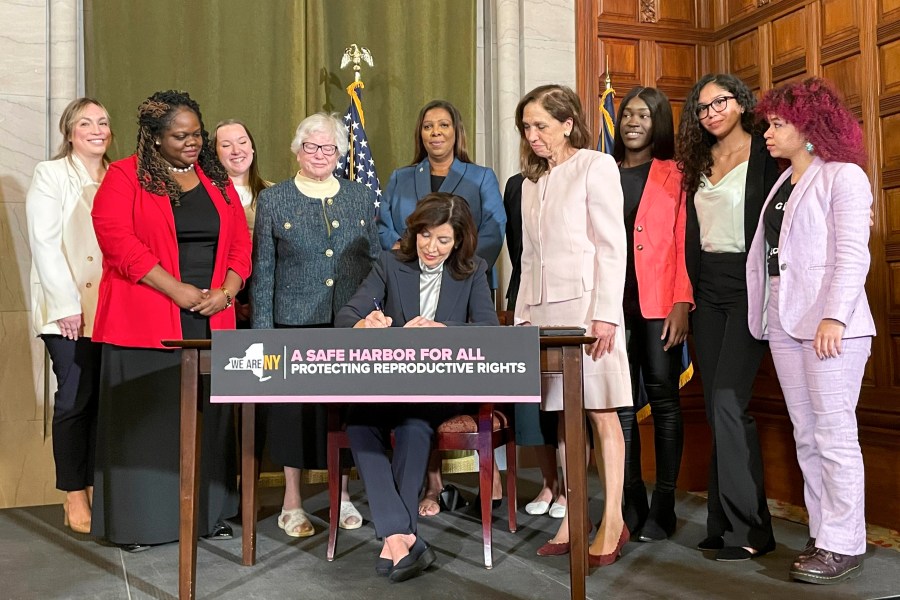 New York Gov. Kathy Hochul, center, signs bills expanding reproductive healthcare that will allow people in New York to receive contraceptives without a doctor's prescription, Tuesday, May 2, 2023, in Albany, N.Y. Under the new law that will go into effect next year, pharmacists will be able to distribute self-administered hormonal contraceptives including oral birth control pills, vaginal rings, and the patch.(AP Photo/Maysoon Khan)