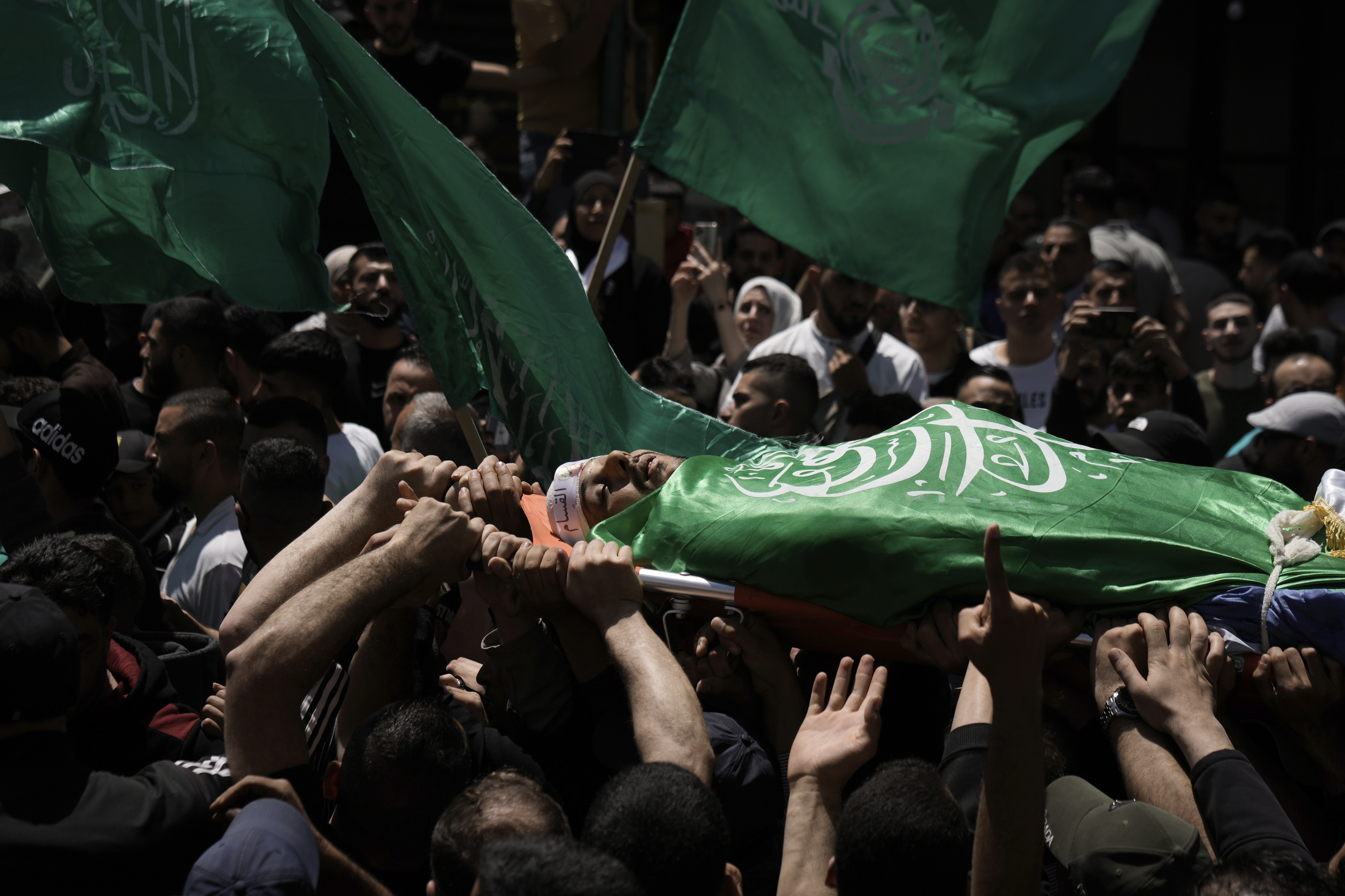 Palestinians carry the body of Hassan Qatnani,, draped in the Hamas militant group flag, during his funeral in the West Bank city of Nablus, Thursday, May 4, 2023. The Israeli military says it has killed Qatnani, Moaz al-Masri and Ibrahim Jabr for being behind an attack last month on a car near a Jewish West Bank settlement that killed a British-Israeli mother and two of her daughters. Hamas said the men were its members and claimed responsibility for the attack (AP Photo/Majdi Mohammed)