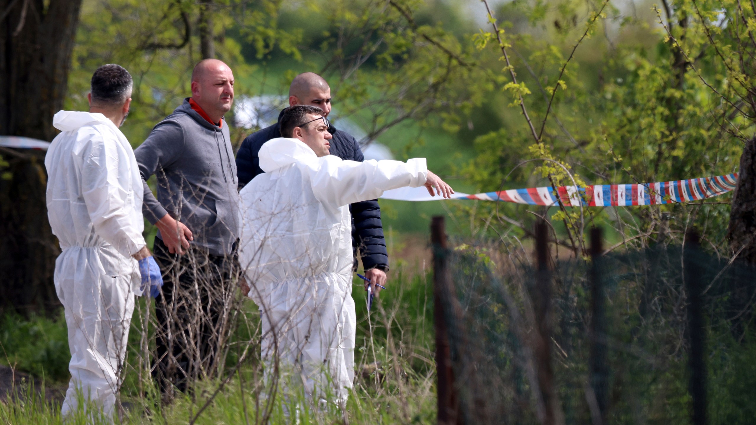 Forensic police inspects the scene around a car in the village of Dubona, some 50 kilometers (30 miles) south of Belgrade, Serbia, Friday, May 5, 2023. A shooter killed multiple people and wounded more in a drive-by attack late Thursday in Serbia's second such mass killing in two days, state television reported. (AP Photo/Armin Durgut)