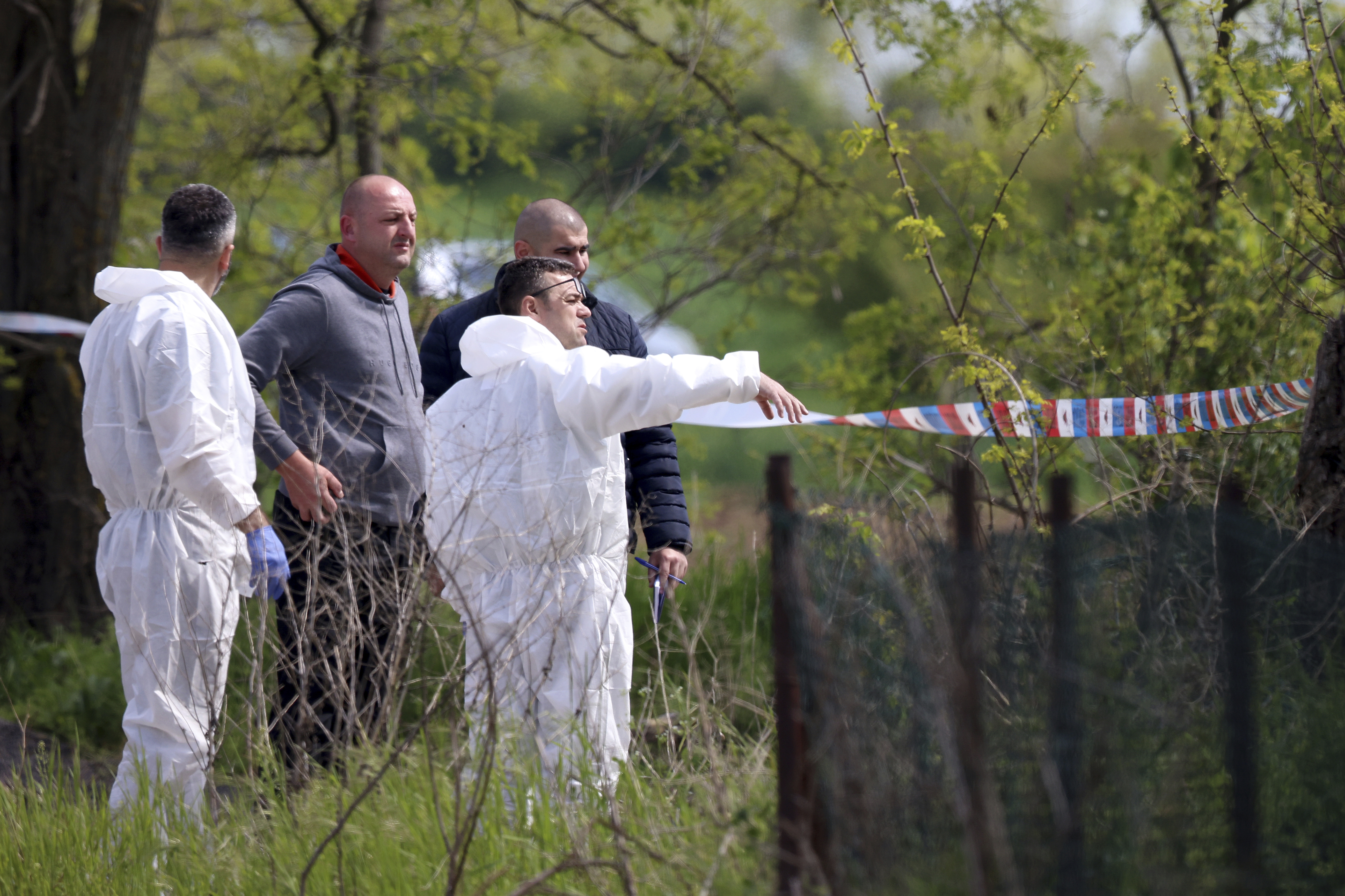 Forensic police inspects the scene around a car in the village of Dubona, some 50 kilometers (30 miles) south of Belgrade, Serbia, Friday, May 5, 2023. A shooter killed multiple people and wounded more in a drive-by attack late Thursday in Serbia's second such mass killing in two days, state television reported. (AP Photo/Armin Durgut)