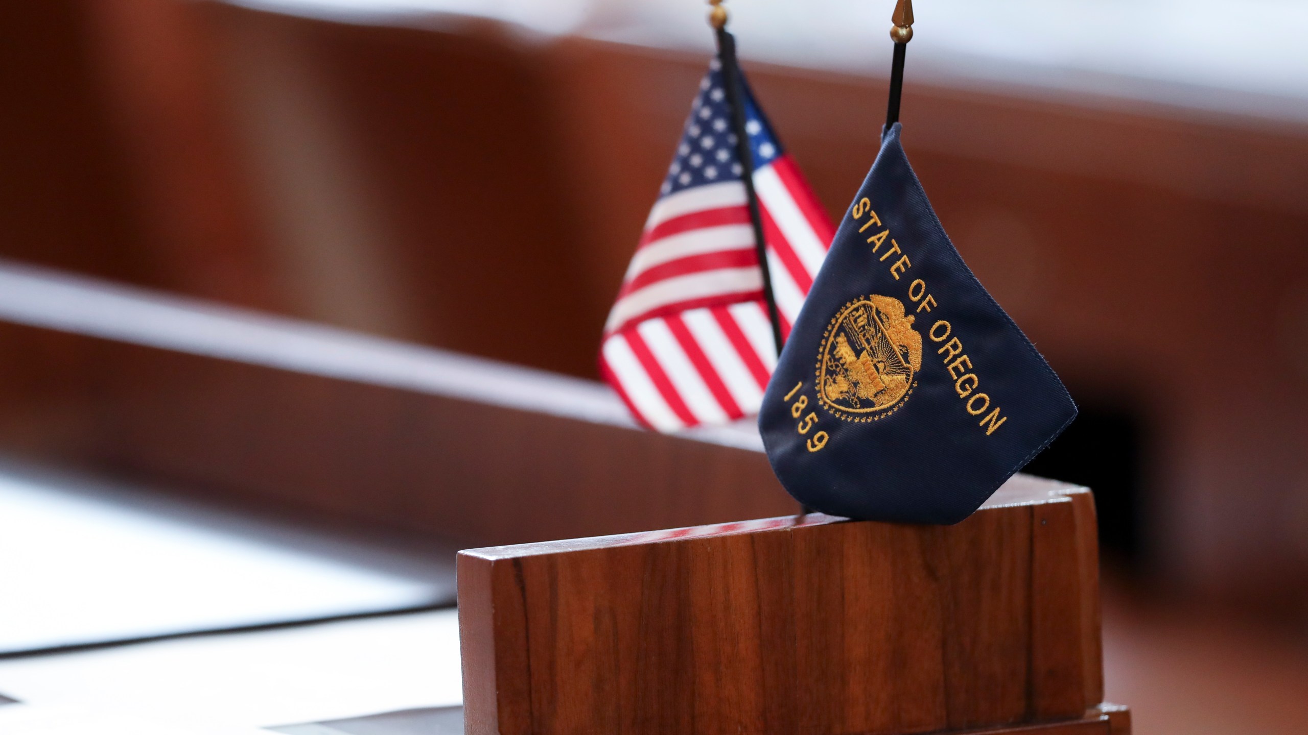 Flags sit on a desk belonging Republican state Sen. Lynn Findley in the Oregon Senate prior to a legislative session at the Oregon State Capitol in Salem, Ore., Friday, May 5, 2023. Sen. Findley, along with three other Republican senators and one Independent senator had unexcused absences during two prior sessions, preventing a quorum. (AP Photo/Amanda Loman)