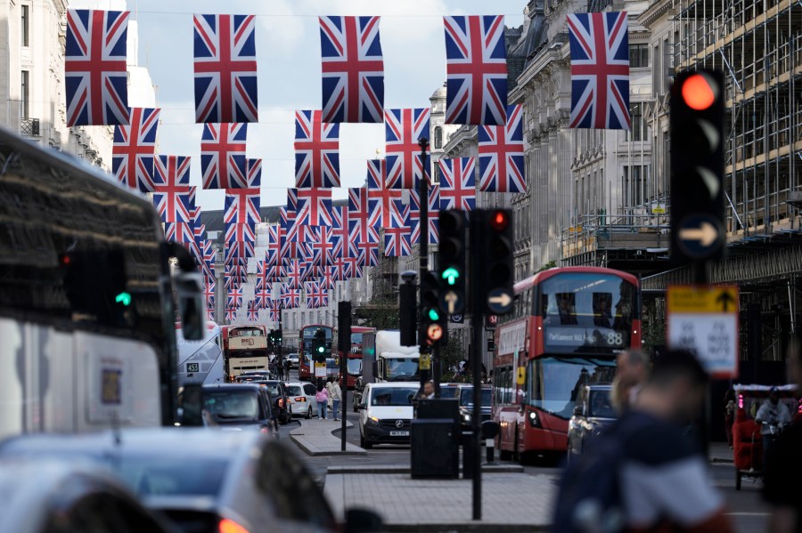 Traffic moves through the decorated Regent Street in central London Friday, May 5, 2023. The Coronation of King Charles III will take place at Westminster Abbey on May 6. (AP Photo/Markus Schreiber)