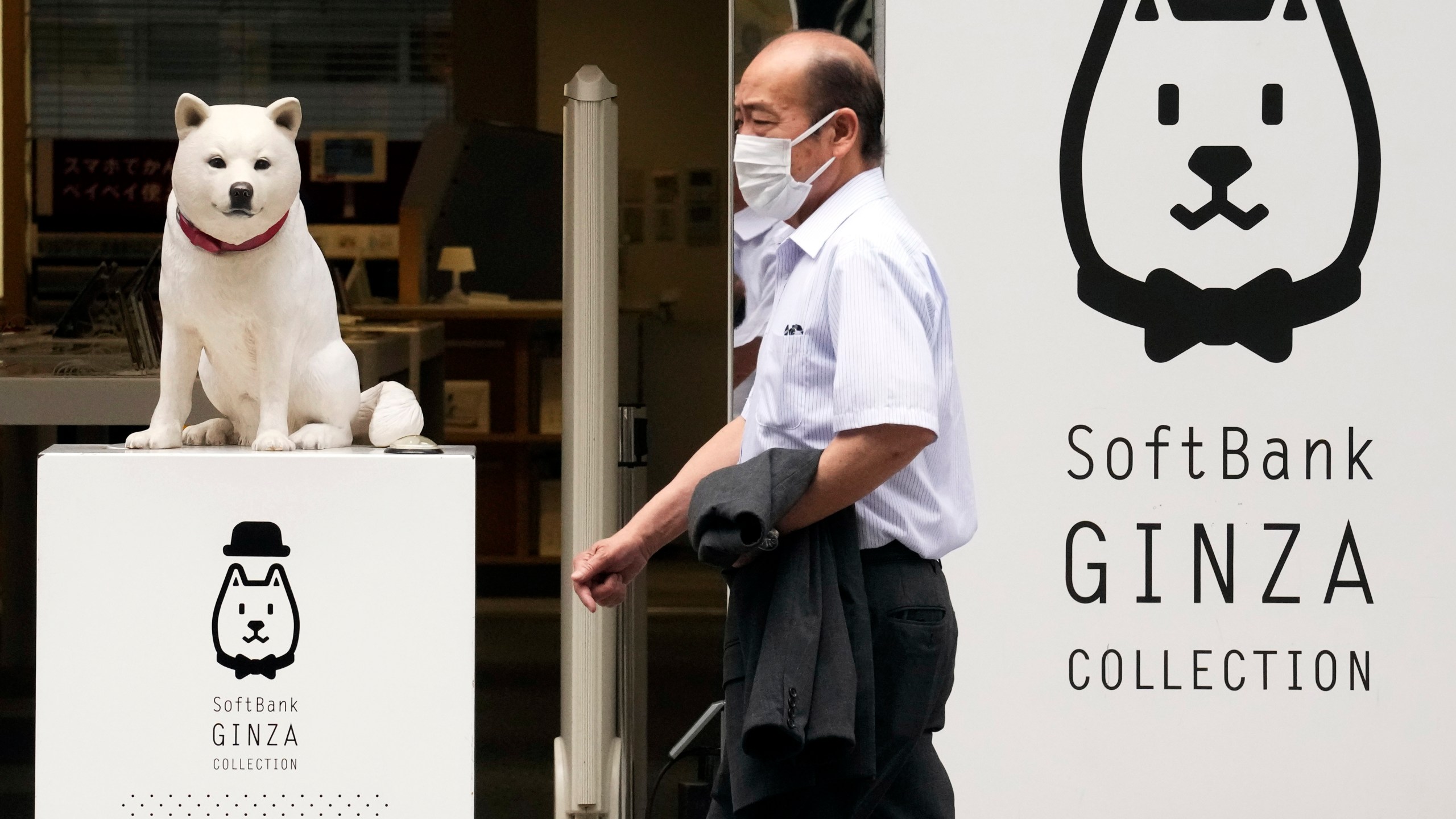 FILE - A man walks past a SoftBank shop in Tokyo on July 29, 2021. Japanese technology investor SoftBank Group reported Thursday, May 11, 2023, a loss of 970 billion yen ($7 billion) for the fiscal year that just ended — the second year in a row of red ink. (AP Photo/Eugene Hoshiko, File)