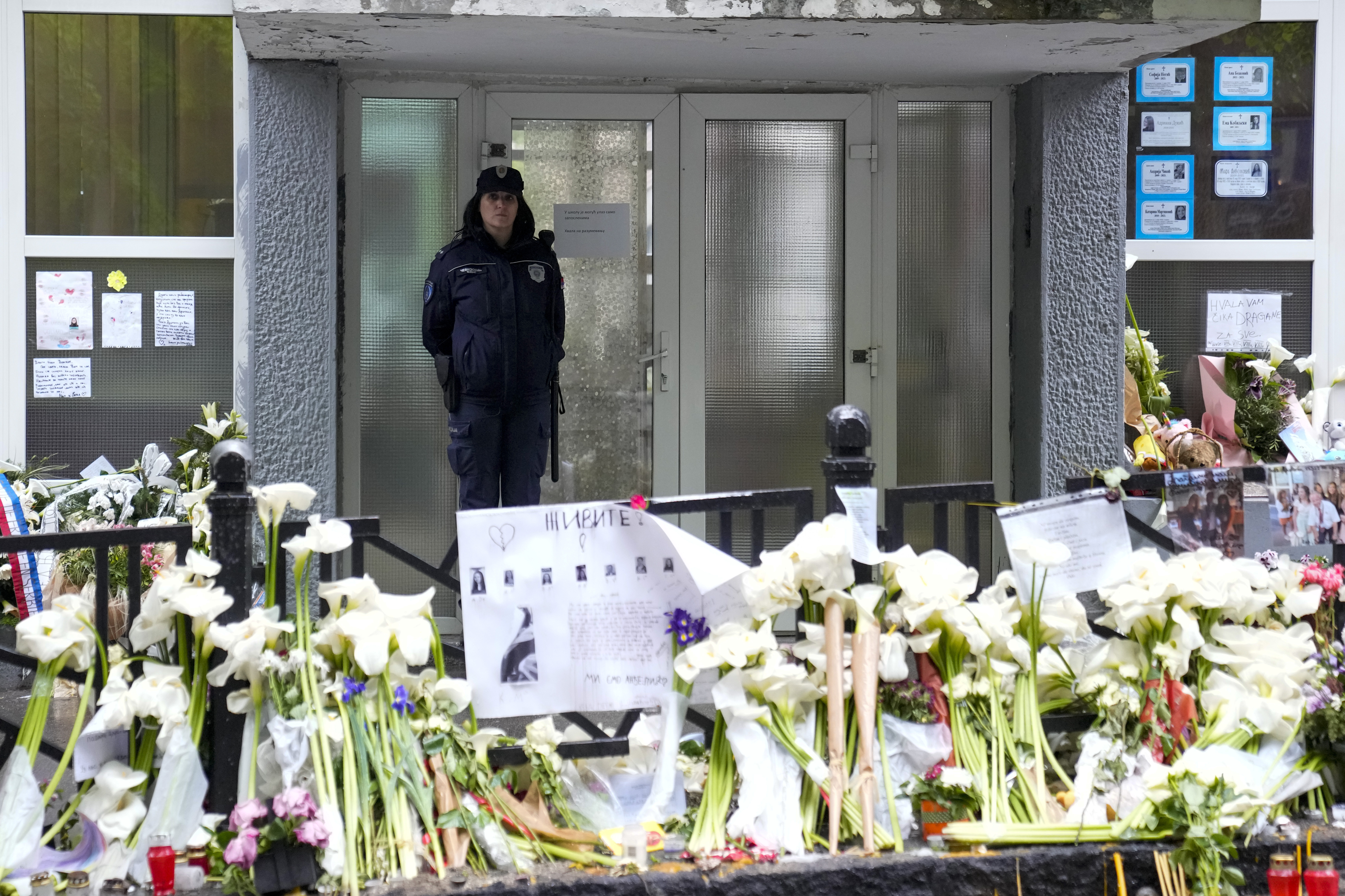 A police officer guards the Vladimir Ribnikar school in Belgrade, Serbia, Monday, May 8, 2023. Police on Monday deployed in schools throughout Serbia in an effort to restore a shaken sense of security following two mass shootings last week - including one in a primary school in Belgrade - that left 17 people dead and 21 wounded, many of them children. (AP Photo/Darko Vojinovic)