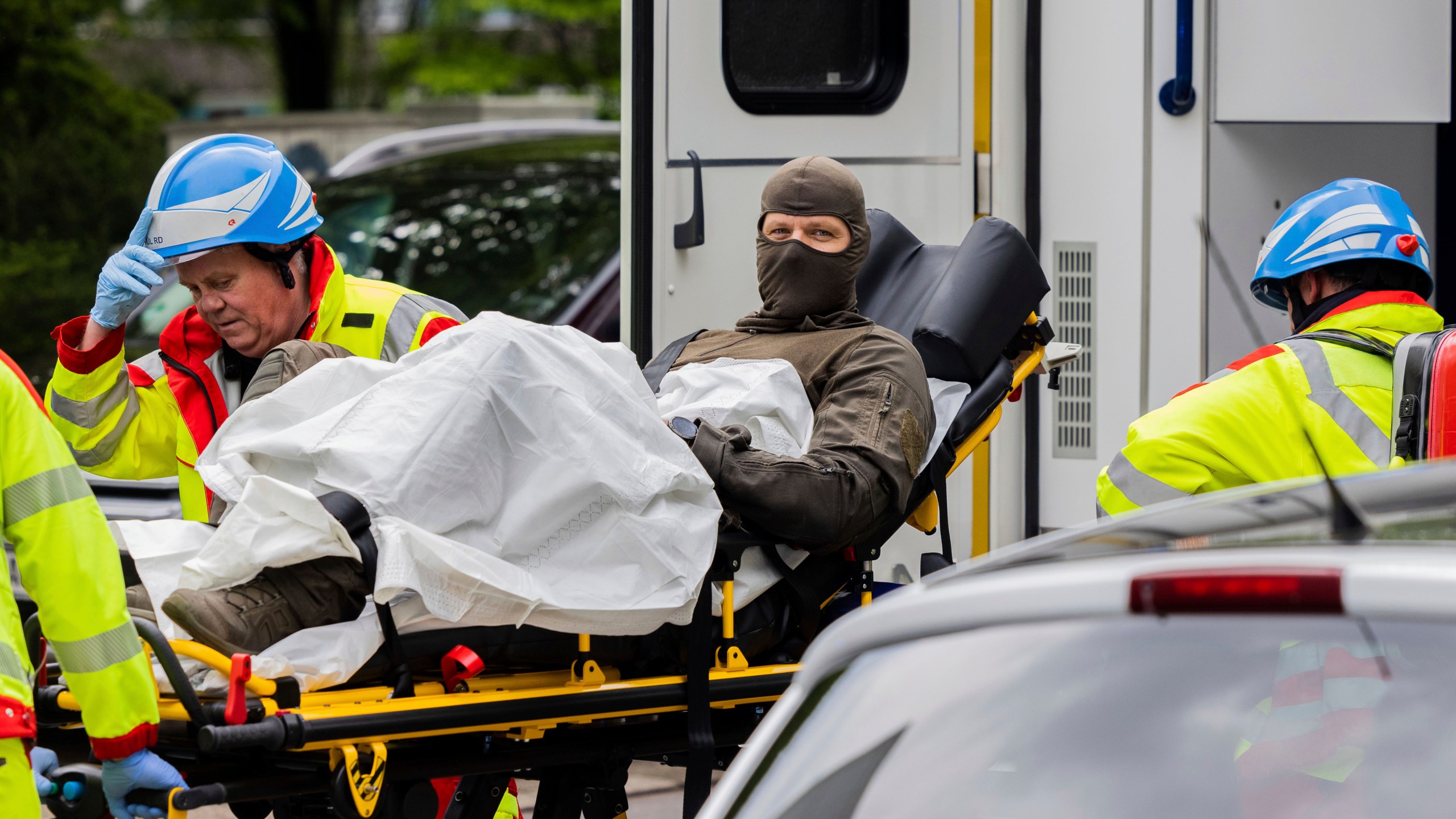 An injured police officer is taken to an ambulance in front of a high-rise building in Ratingen, Germany, Thursday May 11, 2023. A senior security official says at least a dozen people have been injured in an explosion at a residential building in western Germany. Herbert Reul, Interior Minister of the German state of North Rhine-Westphalia, said that 10 firefighters and two police officers were injured in the blast at a high-rise building in the town of Ratingen. (Rolf Vennenbernd/dpa via AP)