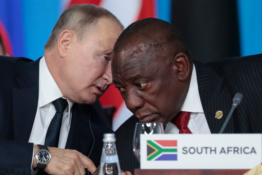 FILE - Russian President Vladimir Putin, left, speaks to South African President, Cyril Ramaphosa, right, during a plenary session at the Russia-Africa summit in the Black Sea resort of Sochi, Russia on Oct. 24, 2019. The U.S. ambassador to South Africa, Reuben Brigety, has accused South Africa of providing weapons to Russia saying the U.S. government was certain that weapons were loaded onto a cargo ship that docked secretly at a naval base near the city of Cape Town for three days in December. (Sergei Chirikov/Pool Photo via AP, File)