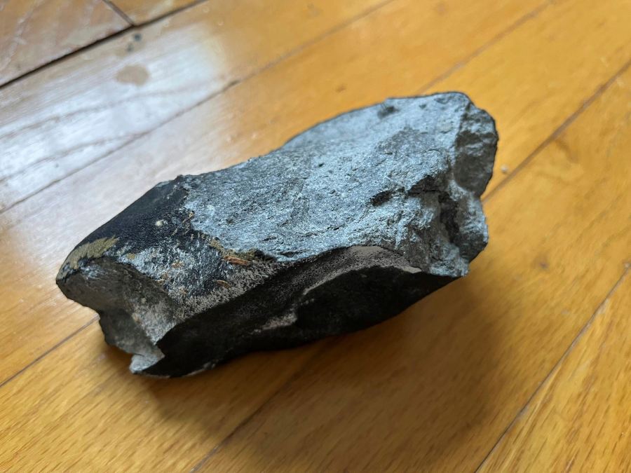 CAPTION ADDITION: CONFIRMED METEORITE: This image provided by Hopewell Township Police Department shows a confirmed meteorite on a hardwood floor at a residence in Hopewell Township, N.J. The meteorite punched a hole in the roof of the central New Jersey home, smashing into a hardwood floor and bouncing around a bedroom. The family who owns the home discovered the black, potato-sized rock in a corner — still warm. (Hopewell Township Police Department via AP)