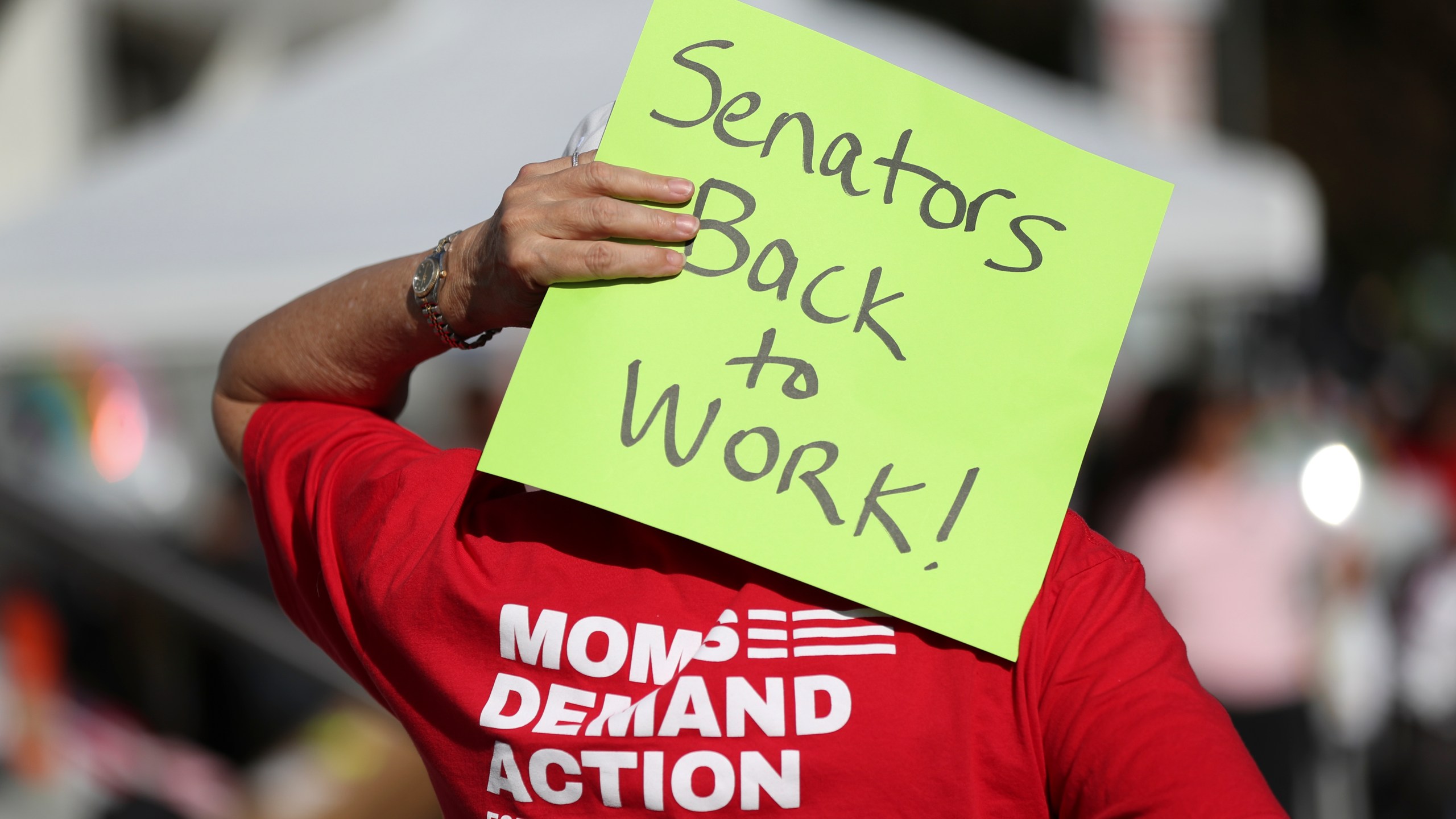 An attendee holds a sign behind their head during a rally calling for an end to the Senate Republican walkout at the Oregon State Capitol in Salem, Ore., Thursday, May 11, 2023. (AP Photo/Amanda Loman)