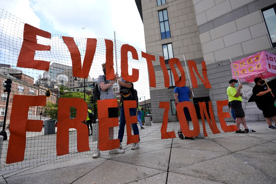 FILE - In this June 9, 2021, photo, people hold a sign during a rally in Boston protesting housing eviction. Housing advocates are raising the alarm about House Republicans' plan to dramatically cut the federal deficit to raise the debt ceiling, warning that struggling families could lose access to rental aid. (AP Photo/Elise Amendola, File)