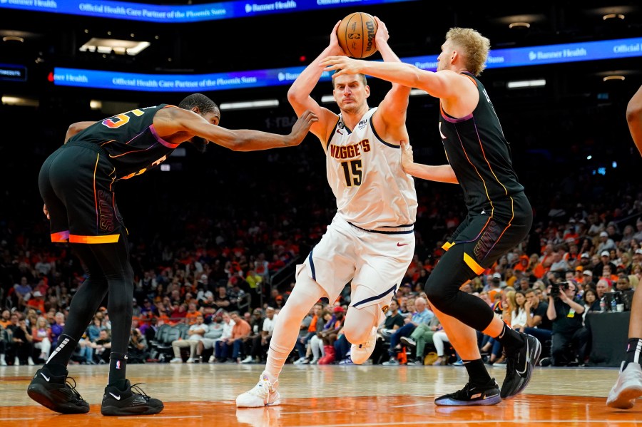 Denver Nuggets center Nikola Jokic (15) drives past Phoenix Suns forward Kevin Durant, left, and center Jock Landale during the second half of Game 6 of an NBA basketball Western Conference semifinal series, Thursday, May 11, 2023, in Phoenix. The Nuggets eliminated the Sun in their 125-100 win. (AP Photo/Matt York)