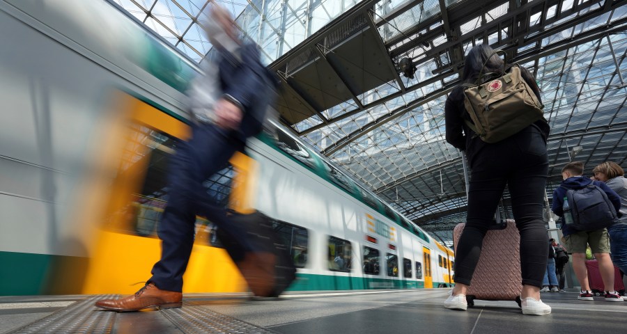 FILE - Travellers wait on a platform as a train arrives at the main train station in Berlin, Germany, Wednesday, June 1, 2022. A labor union representing more than 200,000 railway workers in Germany says it is cancelling plans for a two-day strike after employers met one of its key demands. (AP Photo/Michael Sohn, File)