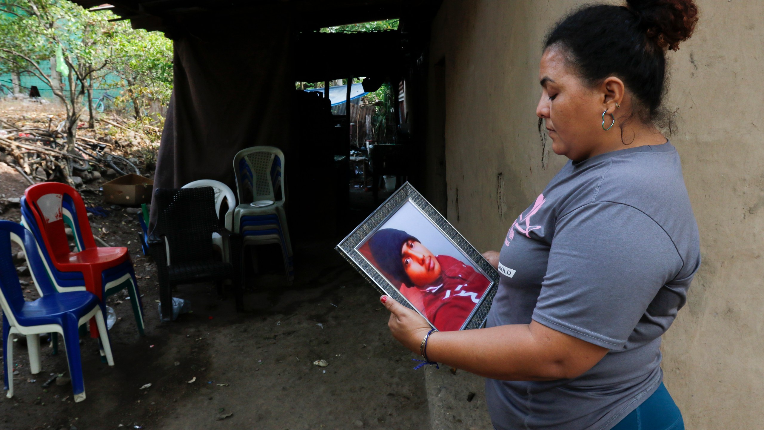 Norma Espinoza holds a portrait of her son Angel Maradiaga, at her home in Olanchito, Honduras, Saturday, May 13, 2023. Maradiaga, 17, who was detained at a facility in Safety Harbor, Florida, died Wednesday. Epinoza is demanding answers from American officials, saying her son had no known illnesses and had not shown any signs of being sick before his death. (AP Photo/Delmer Martinez)