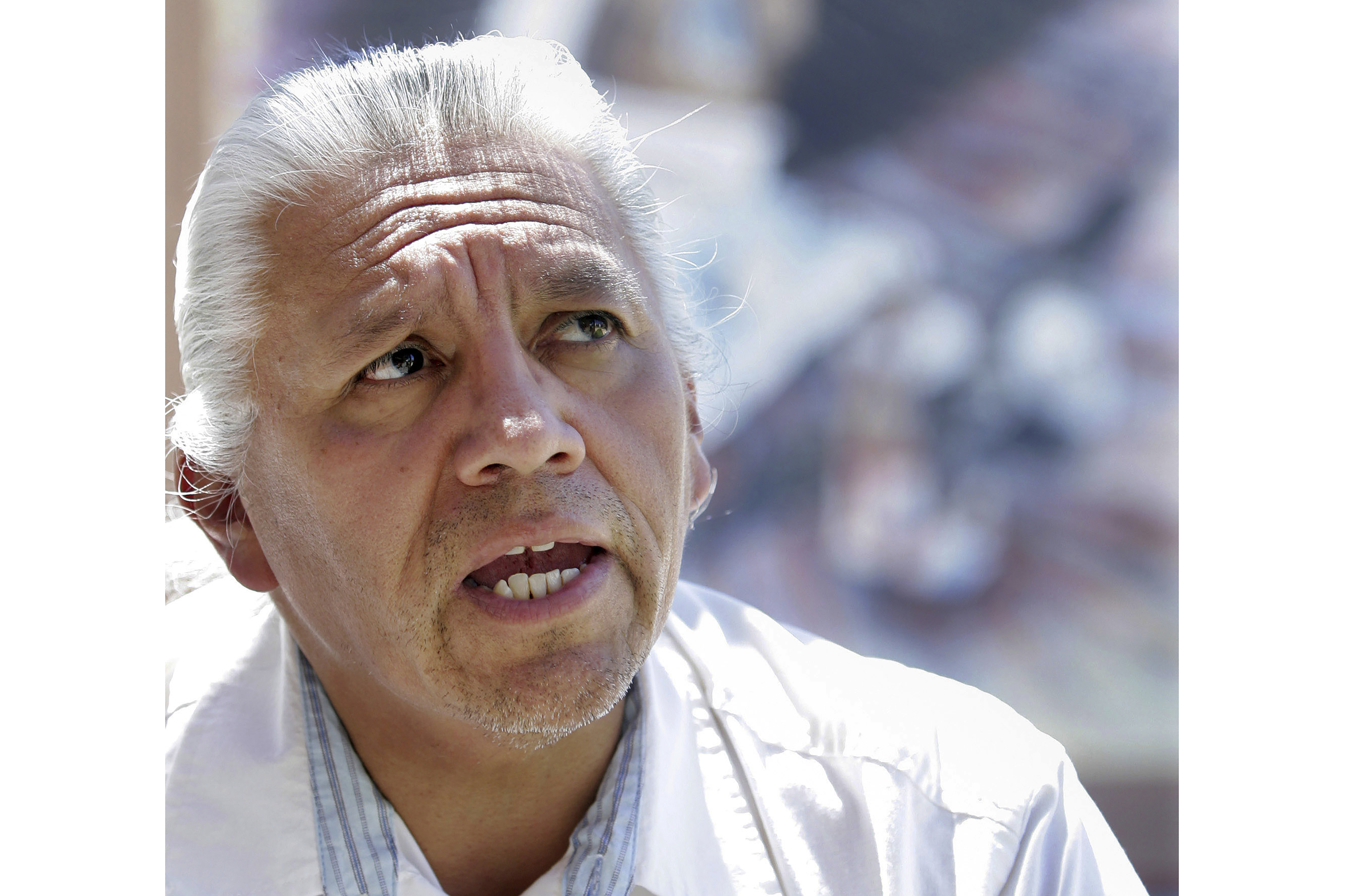 FILE - Joe A. Garcia, governor of northern New Mexico's Ohkay Owingeh pueblo, president of the National Congress of American Indians in Washington, D.C., and the chairman of the All Indian Pueblo Council, stands in front of a mural at the All Pueblo Cultural Center in Albuquerque, N.M., Friday, Aug., 11, 2006. Garcia's family says he has died on Thursday, May 11, at age 70. Based in New Mexico, he was an advocate for tribal sovereignty. Relatives confirmed Garcia died Thursday but did not give a cause of death. A traditional funeral already has been held. (AP Photo/Jake Schoellkopf, File)